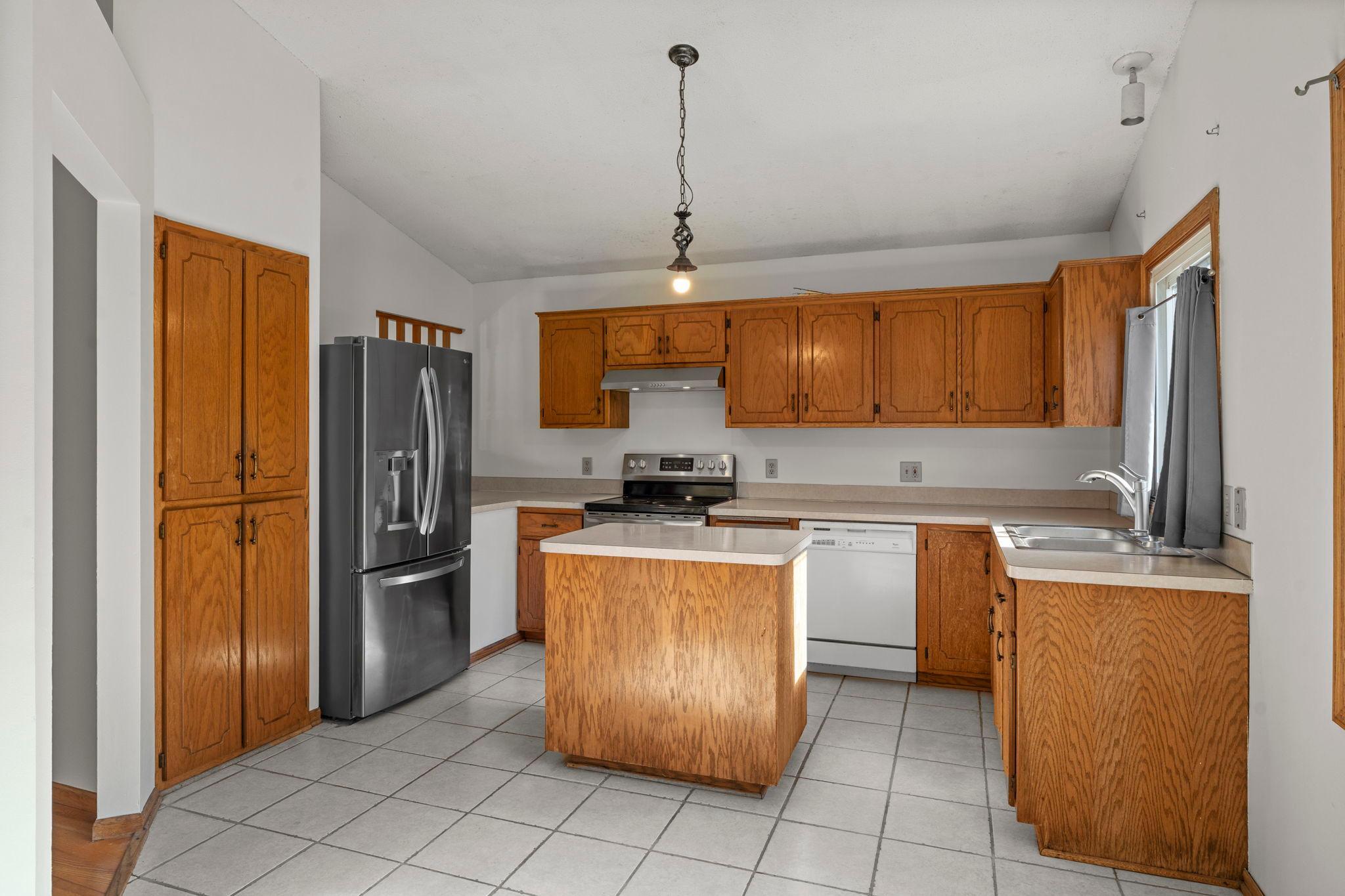 The inviting kitchen features a center island, generous cabinetry, and an easy connection to the dining area, perfect for everyday meals and entertaining.