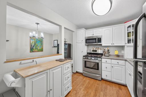 Lovely kitchen with raised panel cabinets, wood floors and stainless steel appliances.