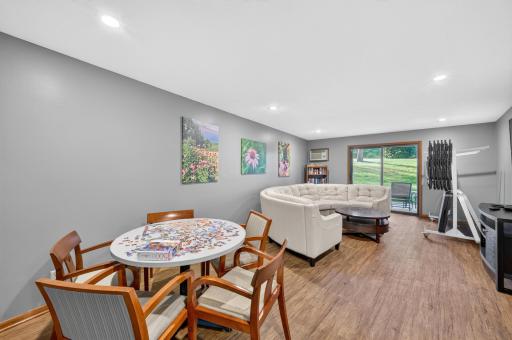 The community room complete with social table, nice couch and large TV and patio doors to the nice patio area.