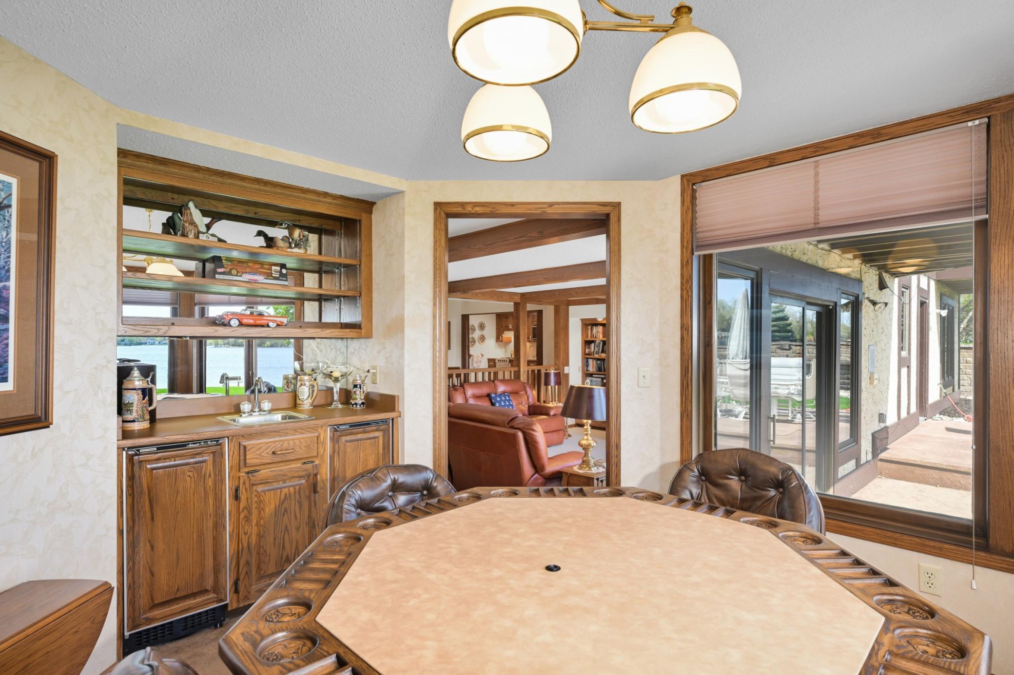 Card room/sunroom featuring a wet bar with ice maker and mini refrigerator.