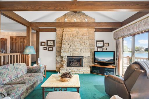 A dramatic stone fireplace and exposed wood beams give the living room its distinctive character.