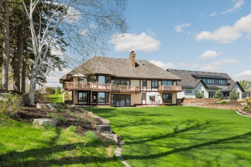 Expansive, beautifully maintained lakeside yard with mature trees and landscaping.