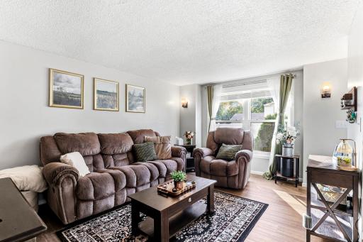 Bright main-level living space with neutral decor, updated flooring and convenient access to both the front entry and upper level.