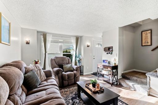 A large front window brings great natural light into the Living Room, complemented by newer LVP flooring and white trimwork.