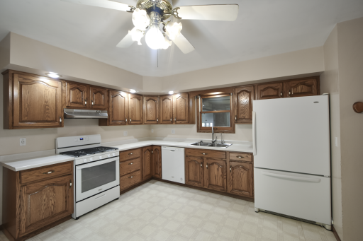 Spacious kitchen with gas range, wood cabinets, large pantry.