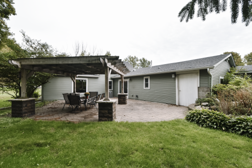 Situated on just under 1/2 acre. The large white door to the right goes into the garage, sliding patio doors into the kitchen making hosting indoor/outdoor events very functional. Maintenance free siding and new roof.