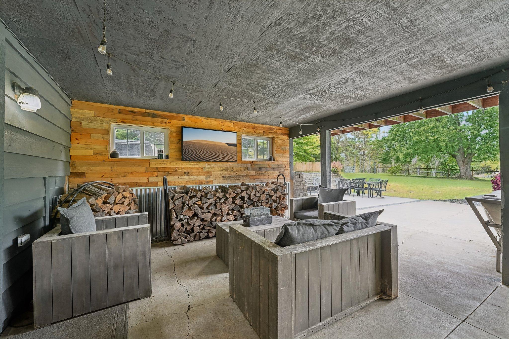 Covered lower level patio to inground pool and view of backyard