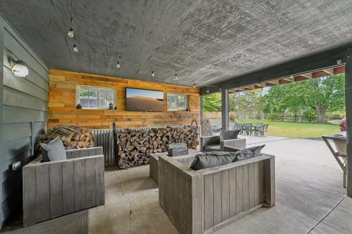 Covered lower level patio to inground pool and view of backyard