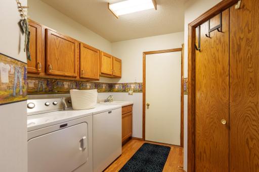 1967 Cherry St. Red Wing-Launrdy room with upper cabinets, built-in laundry sink, and newer washer & dryer (2022). The white door leads to the garage and the door on the right is to a large pantry/storage closet.