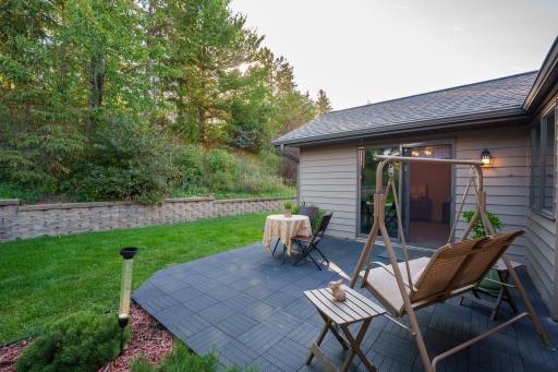 1967 Cherry St. Red Wing-Private back patio facing the wooded hillside with mature trees and flowering shrubs.
