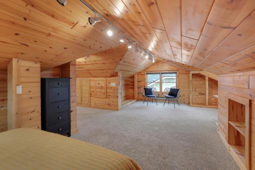 Cozy loft sitting area with warm wood paneling, built-in shelving, and a sunny nook for reading or relaxing.
