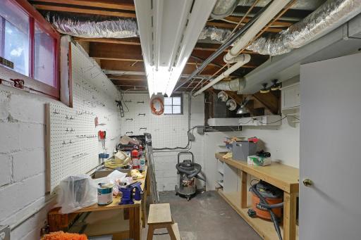 A dedicated lower-level workshop offers a handy space for DIY projects, hobbies, and repairs, with work surfaces and room to organize tools and supplies.