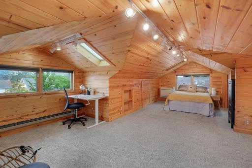 Window-side workspace adds a convenient home office nook to the warm, wood-paneled loft.