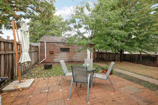 Wood slats along the garage offer a creative spot to hang outdoor dÃ©cor or grow a hanging herb garden, adding a personal touch to your backyard retreat.