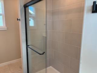 Elegently Tiled Primary Shower With Glass Door.jpg