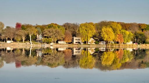 A stunning view of the shoreline with fall colors popping, a perfect vantage point as you take an evening pontoon cruise.