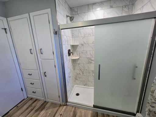 Tile walk in shower with plenty of storage space.