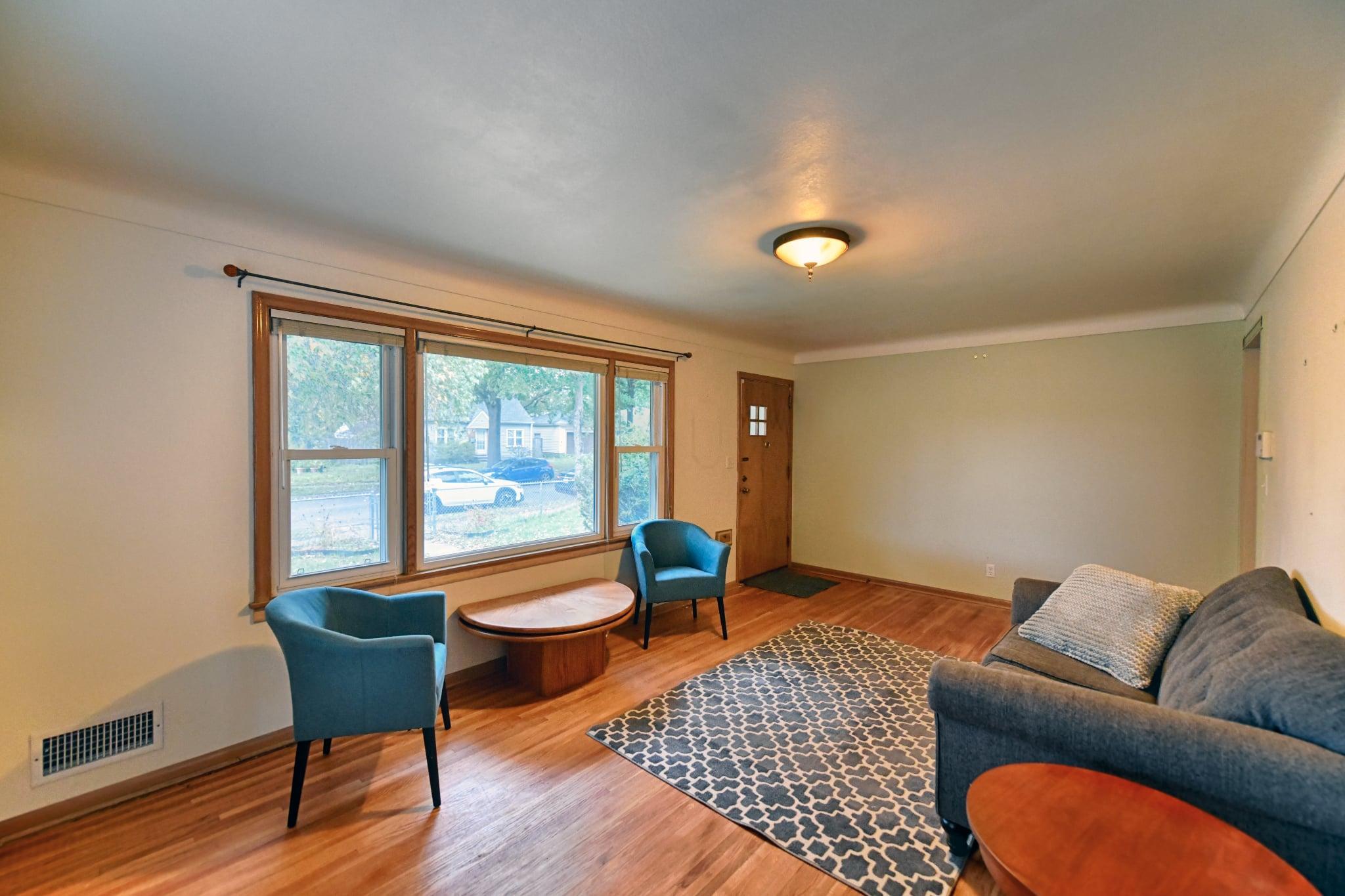 Good-sized living room has hardwood floors and large window.