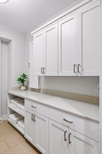 Centrally located laundry room with plenty of storage adds convenience and functionality.
