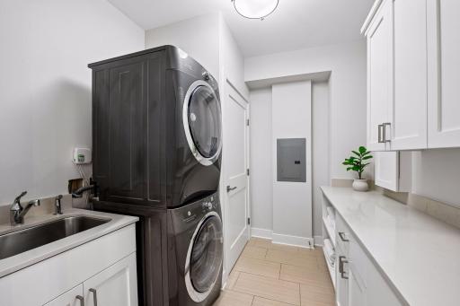 Centrally located laundry room with plenty of storage adds convenience and functionality.