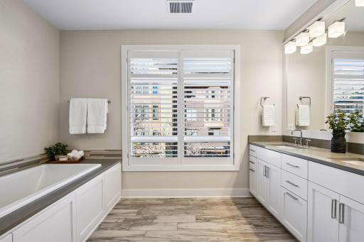Spa-like primary bath features a separate soaking tub, double sinks, walk-in shower, and private toilet area.