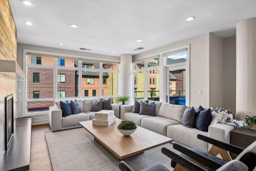Corner-unit living room is surrounded by windows, filling the space with natural light and bringing the outdoors in.