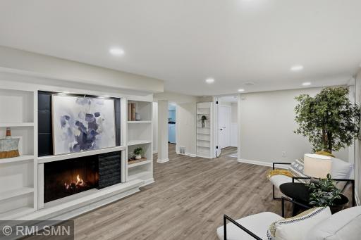 Cozy fireplace is adorned with comfortable seating areas and new flooring in the lower level. Fireplace has not been used by the owners.
