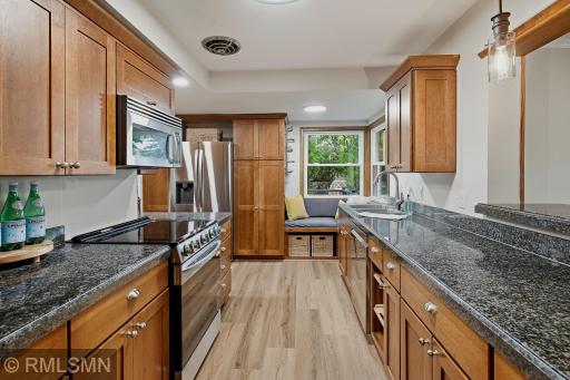 Galley style kitchen offers extra space for the refrigerator, pull out garbage and recycling, and bench seating overlooking the back yard.