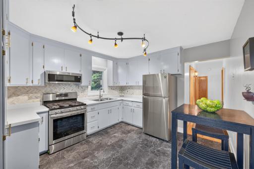 The kitchen is freshly renovated with new flooring, backsplash, and hardware!