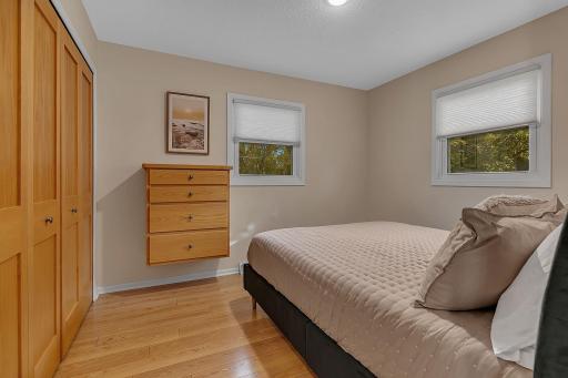 Second bedroom with queen bed on the main with built-in dresser and closet organizers.