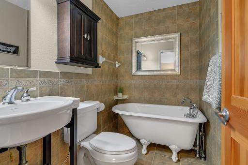Charming main-level 3/4 bath with a classic clawfoot tubâperfect for a relaxing soak after a day on the links or the lake