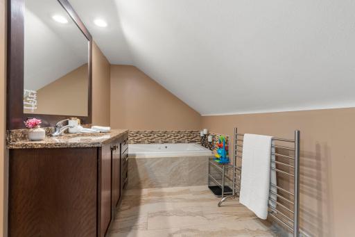 The third bathroom is located on the upper level and features a relaxing soaking tub.