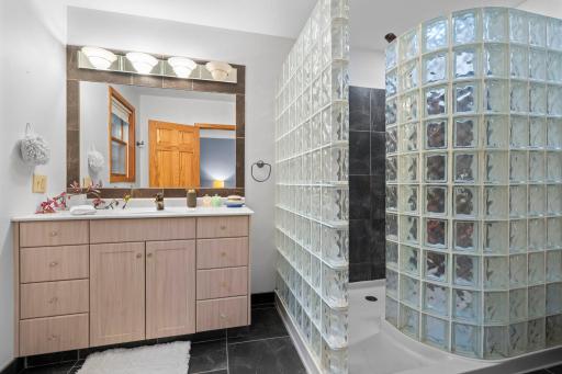 The primary ensuite features a spacious walk-in shower with a stunning stone surround.