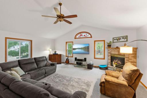 The spacious living room features a gas fireplace, 11 foot vaulted ceilings, and stained glass windows.