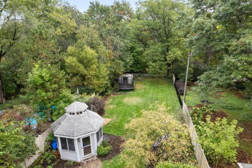 Pergola located in the backyard just off the paver patio, creating a comfortable spot for outdoor relaxation and entertaining.