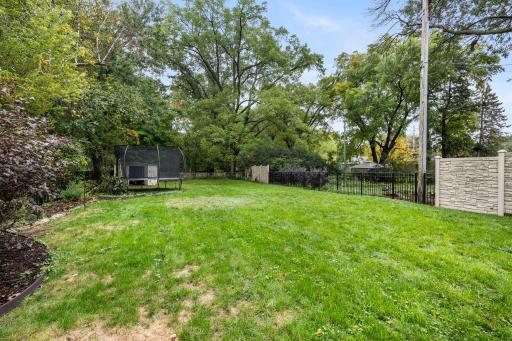 Spacious backyard that is partially fenced and wooded, offering privacy and a peaceful setting.