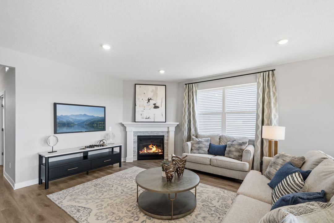 The cozy gas fireplace is a fantastic addition to the living room. This room is perfect for gathering with friends and family. Photo of model home, colors and fireplace surround may vary.
