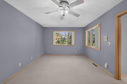 The large primary bedroom also looks onto the wooded backyard.