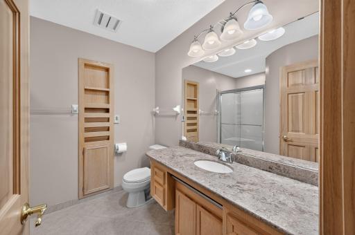 Primary bath has heated tile floors and custom built-ins.