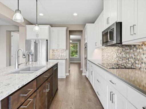 Kitchen looking at the formal dining room in front of home, and along the way is a walk in pantry and a serving counter and builtins