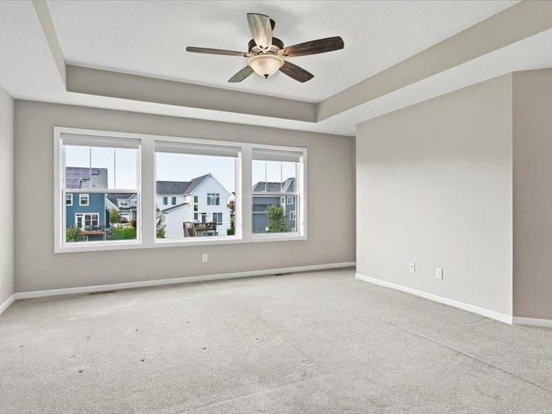 The primary bedroom is very large with huge windows to the back, and detailed ceiling treatment