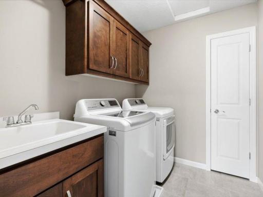Upper level laundry with sink and built ins. plus a handy linen closet