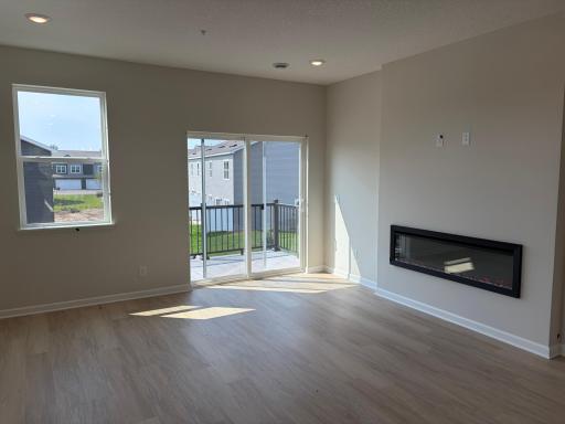 This spacious living room has excellent scenery featuring large windows, a fireplace, and enough space for even the biggest couches.