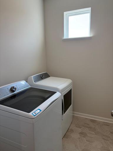 The laundry room features ample space with room above to add shelving.