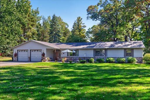 Welcoming exterior featuring attractive brick accents, an oversized attached garage, and beautifully maintained landscaping.