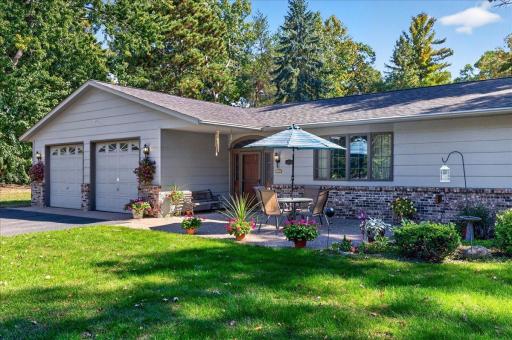 Inviting front patio surrounded by colorful flowers and landscaping, perfect for relaxing outdoors.