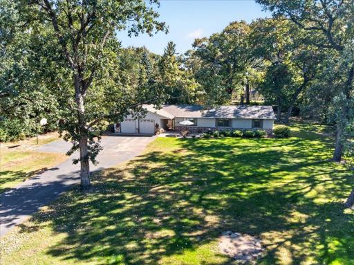 Elevated view showcasing the home's attractive exterior, paved driveway, and beautifully landscaped surroundings.