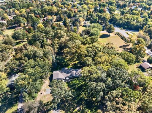 Bird's-eye view capturing the home's private, wooded surroundings and convenient location.