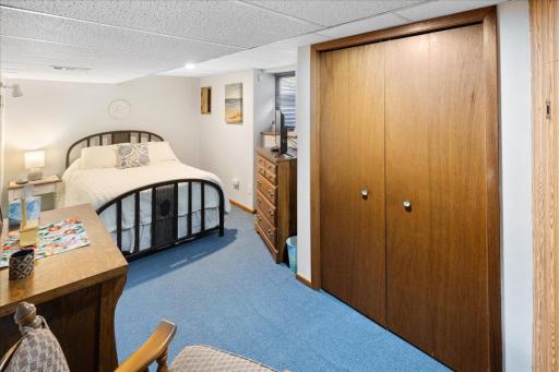 Spacious lower-level bedroom featuring neutral wall and a window for natural light. Plenty of room for guest accommodations or additional living space.