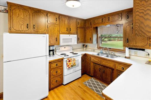 Well-maintained kitchen offering generous oak cabinetry, ample countertop space, and a window above the sink overlooking the beautiful backyard.